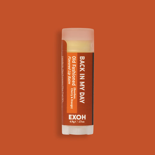 Product photo of old fashioned flavored lip balm "Back In My Day" by EXOH on whiskey colored background.