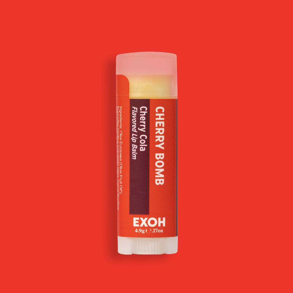 Product photo of cherry cola flavored lip balm "Cherry Bomb" by EXOH on red background.