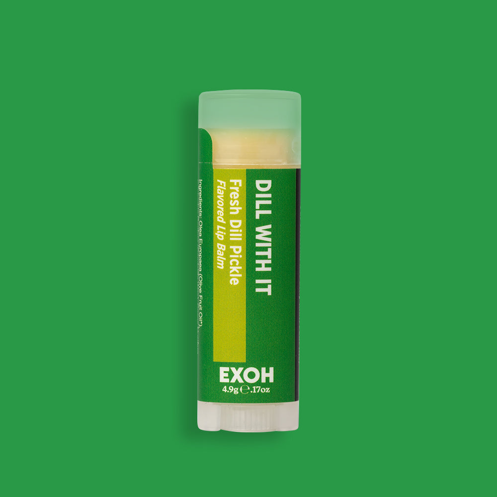 Product photo of fresh dill pickle flavored lip balm "Dill With It" by EXOH on bright green background.