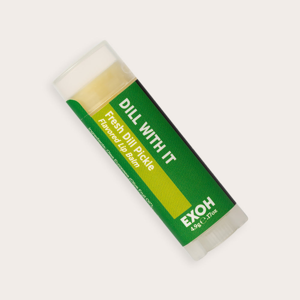 Product photo of fresh dill pickle flavored lip balm "Dill With It" by EXOH on grey background.