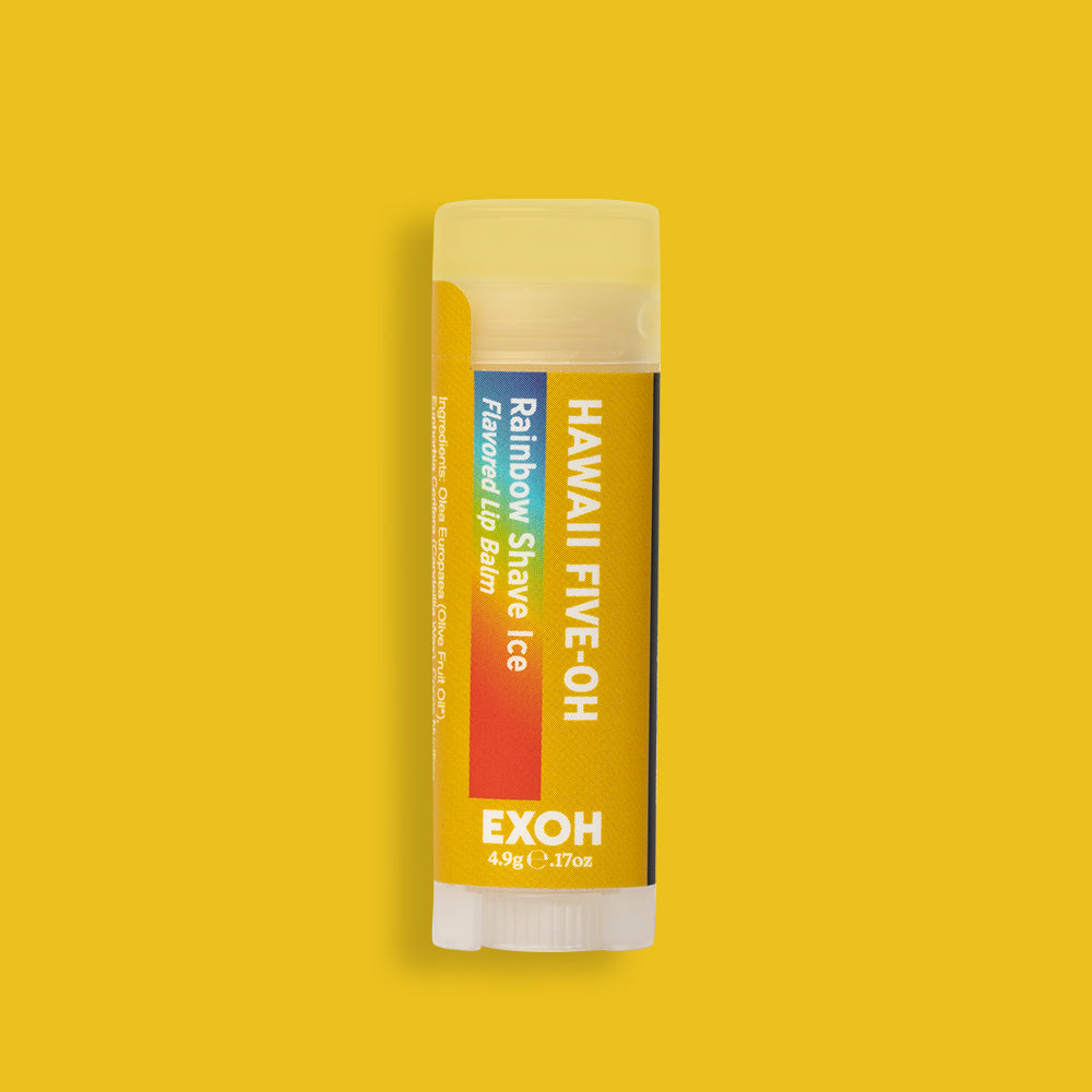 Product photo of rainbow shave ice flavored lip balm "Hawaii Five-OH" by EXOH on bright yellow background.