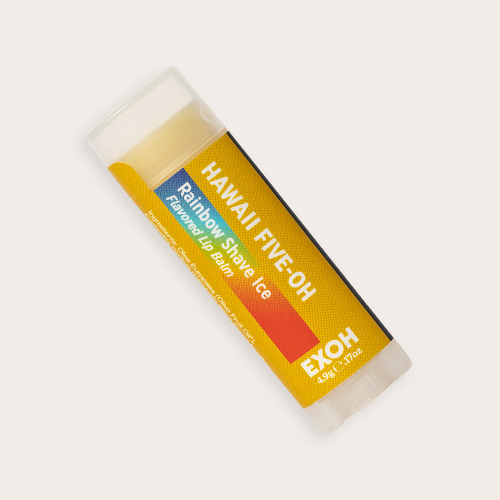 Product photo of rainbow shave ice flavored lip balm "Hawaii Five-OH" by EXOH on grey background.