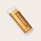 Product photo of almond biscotti flavored lip balm "Hottie Biscotti" by EXOH on grey background.